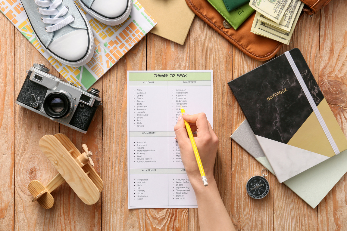 Woman Making Check-List of Things to Pack for Travel